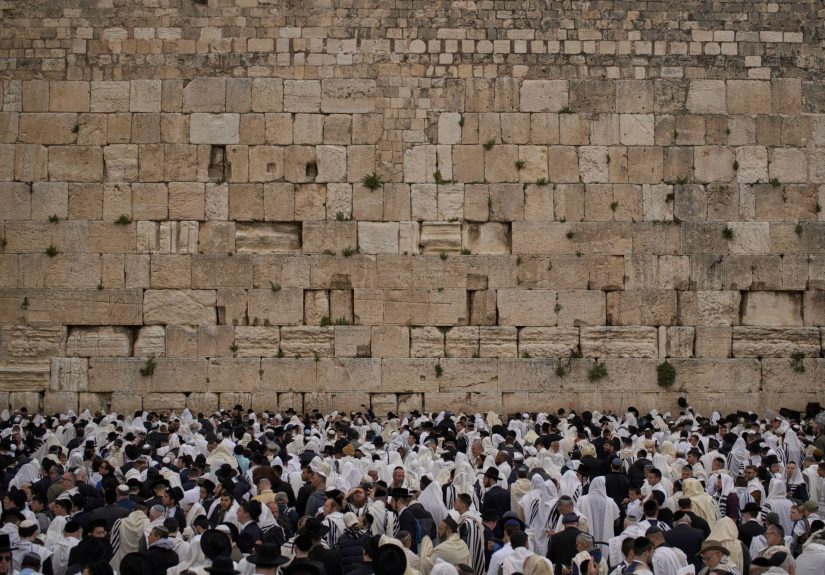 Covered in prayer shawls, Jewish men of the Cohanim Priestly caste participate in a blessing during the holiday of Passover, at the Western Wall, the holiest site where Jews can pray, in the Old City of Jerusalem, Tuesday, April 15, 2025. (AP Photo/Leo Co